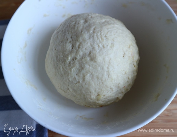В пшеничной муке сделать углубление, налить молочную смесь с дрожжами, перемешать, замесить тесто. Скатать тесто в шар, поместить его в кастрюлю или миску, накрыть влажным (не мокрым!) полотенцем. Дать постоять 1,5 часа.