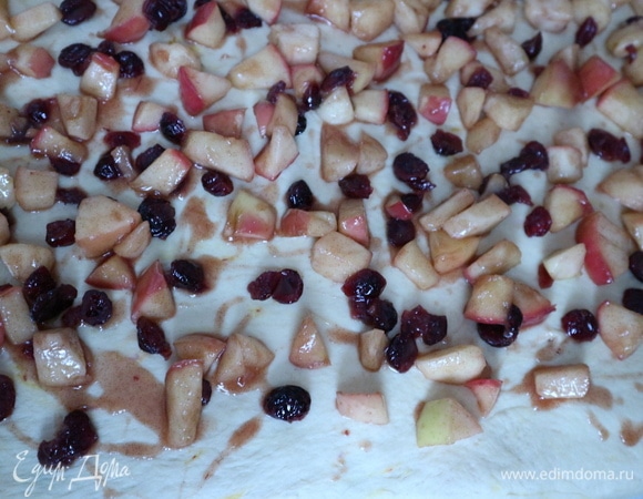 Раскатать тесто в прямоугольник на поверхности, посыпанной мукой. Лишнюю жидкость из начинки слить. Положить равномерно начинку, отступив на несколько сантиметров от края по длинной стороне.