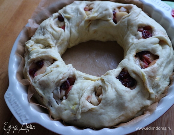 Духовку разогреть до 200°C. Форму и бумагу для выпечки смазать оливковым маслом. Поместить рулет в форму, свернув по кругу, края соединить. Ножницами сделать несколько разрезов по кругу, чтобы начинка была видна. Немного расширить «окошечки» в тесте. Дать постоять 25–30 минут.