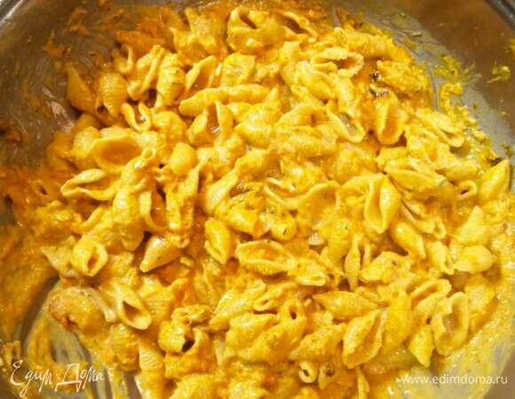 Пасту хорошо перемешиваем с соусом. Добавляем немного тертого сыра, грамм 30. Снимаем с огня и раскладываем по тарелкам.