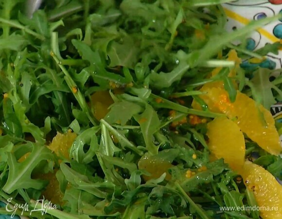 Руколу и мякоть апельсина выложить в салатник, посыпать цедрой, полить половиной заправки и все перемешать.