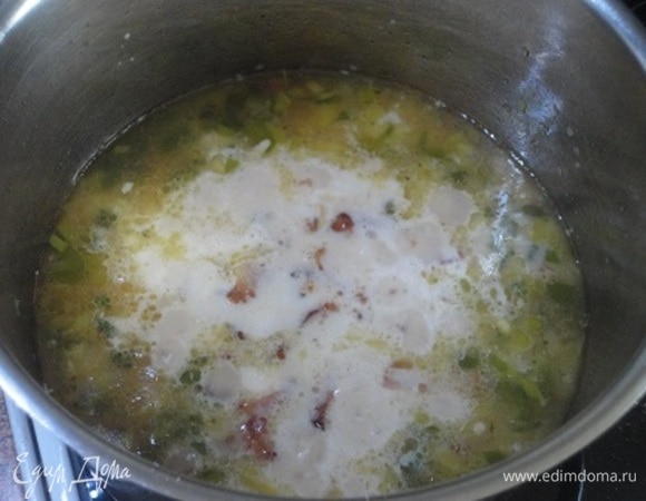 Уменьшите огонь до минимума и добавьте сливки. Добавляйте натертый сыр частями, перемешивая после каждого добавления и давая сыру расплавиться.