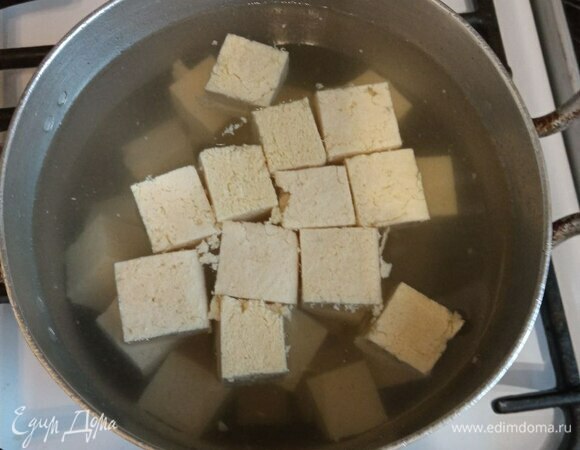 Тофу нарезаем средним кубиком. Теперь его нужно бланшировать. Это делается, чтобы прогреть тофу перед жаркой и убрать запах и привкус соевых бобов. Заливаем тофу водой, чтобы покрывала полностью, и ставим на огонь. Как только вода начнет закипать, сливаем тофу.