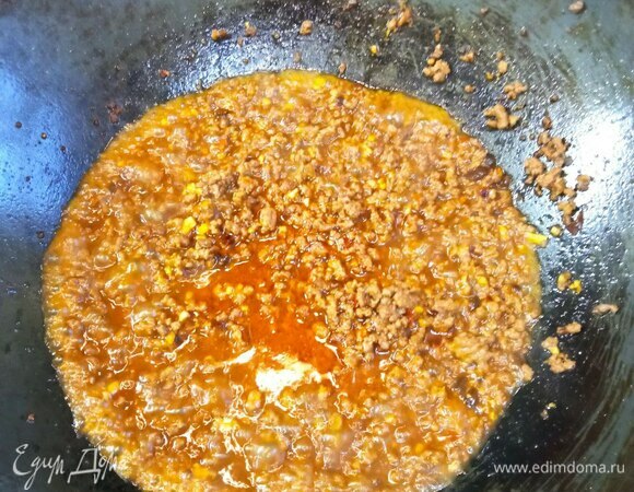 Добавляем примерно 100 мл воды, рисовое вино и соевый соус. Добавляем соль, сахар и глутамат, хорошо перемешиваем и даем закипеть.