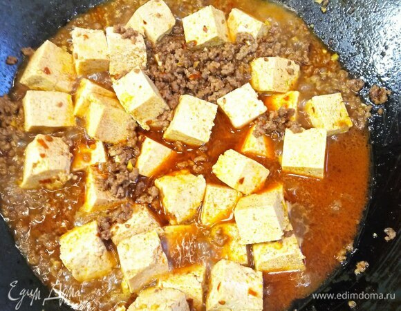 Добавляем тофу и оставляем на 5 минут, чтобы выпарить лишнюю воду, периодически помешиваем. Крахмал разводим в 0,5 стакана воды и постепенно добавляем в вок. Количество воды с крахмалом регулируйте сами, добившись желаемой густоты соуса.