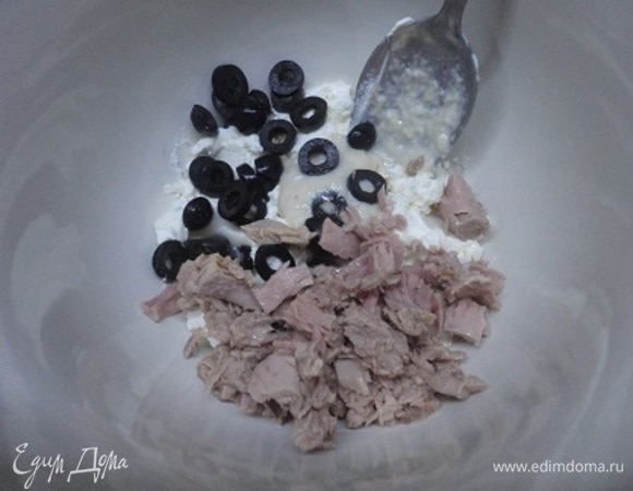 В глубокую миску поместить сыр и добавить оливки, тунца и сливочный хрен. Еще раз перемешать.