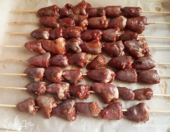 Шпажки заранее замочить в воде. Нанизать на них сердечки. Выложить в форму на пергамент.