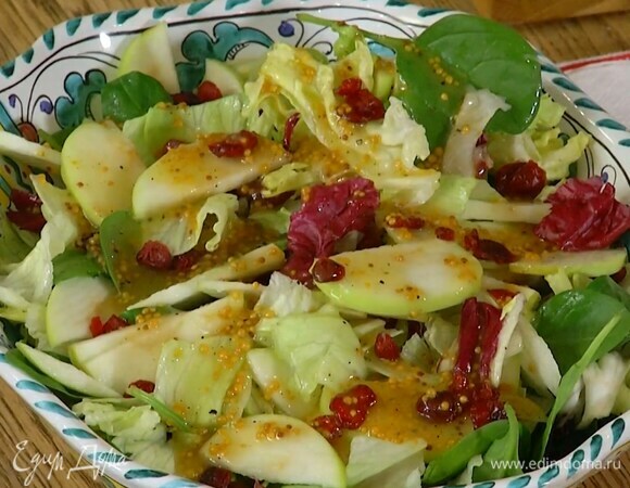 Салатные листья и нарезанные яблоки выложить в глубокую тарелку, посыпать клюквой, полить заправкой.