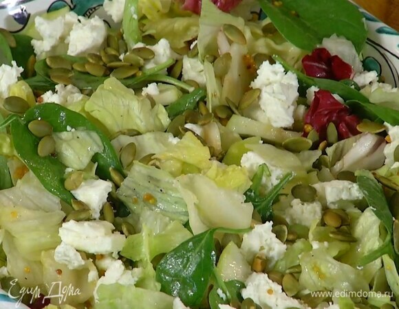 Козий сыр разделить на кусочки и выложить на салат, сверху посыпать тыквенными семечками.