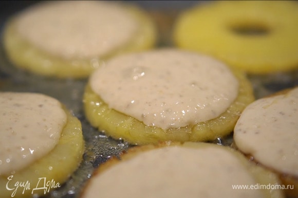 Разогреть в блинной сковороде сливочное масло и обжаривать ананасы до появления золотистой корочки, затем перевернуть и выложить на каждое кольцо по 1 ст. ложке теста.