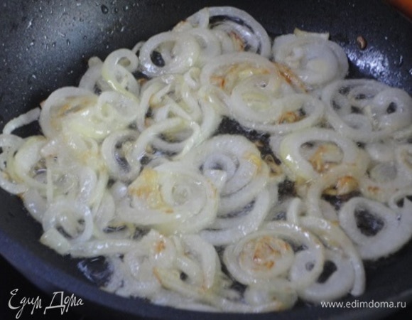 Лук нарезать тонкими кольцами и обжарить в 2 ст. л. масла вместе с рубленым чесноком.