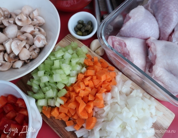 Репчатый лук, морковь почистить, нарезать кубиками, стебель сельдерея нарезать на кусочки. Нарезать болгарский перец на средние кубики. Почистить чеснок. Раздавить зубчики с помощью ножа. Шампиньоны (у меня здесь мини-шампиньоны) ополоснуть, почистить, нарезать на четвертинки. Куриные окорочка (770 грамм) нарезать на две части, отделив бедро от голени. Посолить, поперчить, добавить итальянские травы.