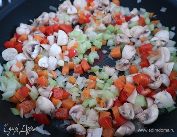 В это время, пока готовится курица, на другой сковороде с добавлением оливкового масла (1,5 столовые ложки) обжарить слегка овощи — лук, морковь, стебли сельдерея, через пару минут добавить болгарский перец, грибы, обжарить немного.
