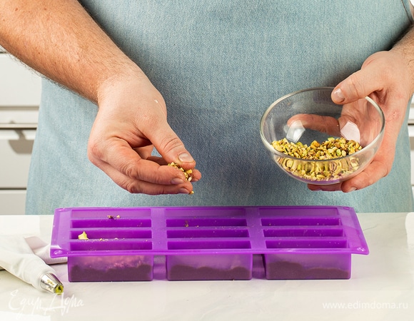 Вылейте в формочки тесто и посыпьте заготовки сверху измельченными фисташками.