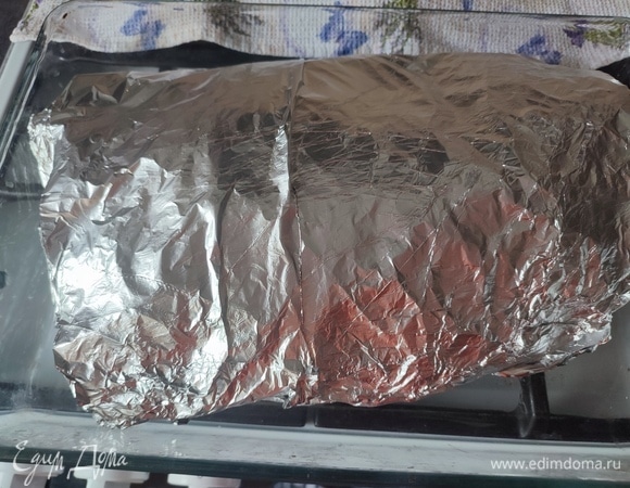 Завернуть мясо в в пергамент, а потом в фольгу. Запекать 2 часа при температуре 150°C.