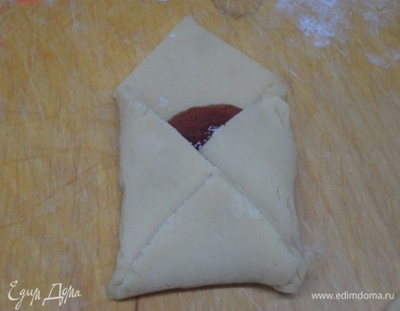 Раскатываем тесто на припыленной мукой поверхности в пласт толщиной около 4 мм и разрезаем на квадратики примерно 9 х 9 см. В центр каждого квадрата помещаем одну чайную ложку джема. Загибаем края в виде конверта.