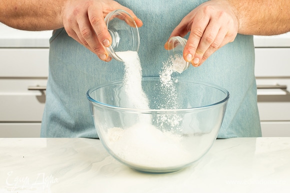 Просейте пшеничную муку в миску. Добавьте половину сахара и разрыхлитель теста. Перемешайте.