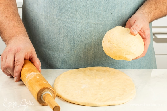 Достаньте рубленое дрожжевое тесто на маргарине «Пышка» из холодильника и разделите на две равные части. Раскатайте каждую в пласт толщиной 5 мм.