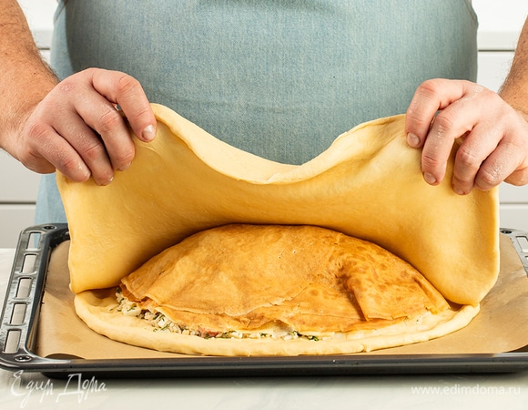 Накройте вторым пластом и заверните края теста. Накройте заготовку полотенцем и оставьте при комнатной температуре на 30 минут. Этого времени хватит, чтобы разогреть духовку до 180°С.