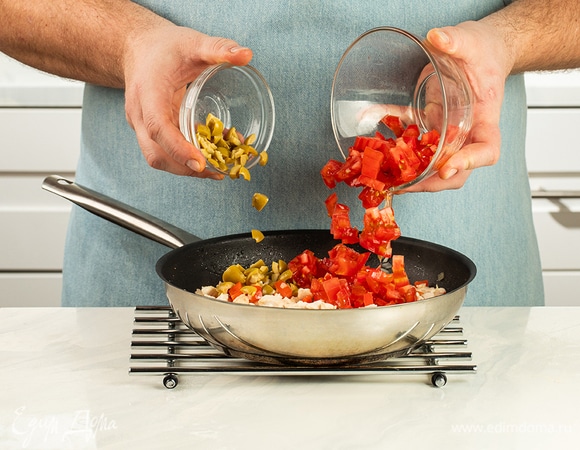 Добавьте нарезанный помидор и оливки.