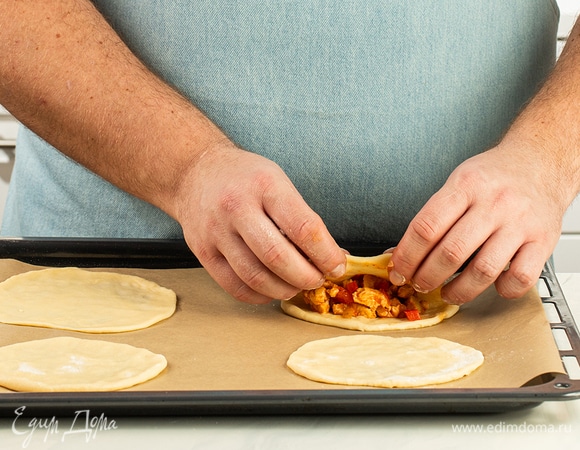 На одну половину положите начинку, смочите края водой и накройте смесь второй частью теста. Пройдитесь по шву пирожка вилкой.