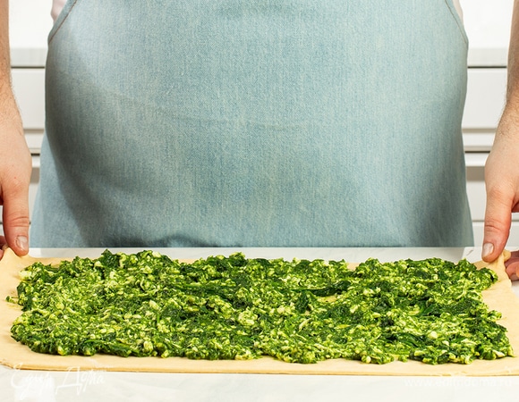 Тесто раскатайте в прямоугольный пласт. Выложите в середину начинку из шпината и сыра.