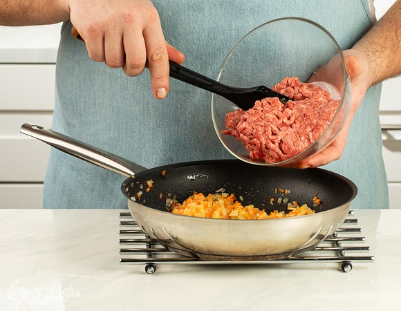 Положите фарш, хорошо разбейте все комочки и обжаривайте до тех пор, пока мясо не изменит цвет, а лишняя жидкость испарится.