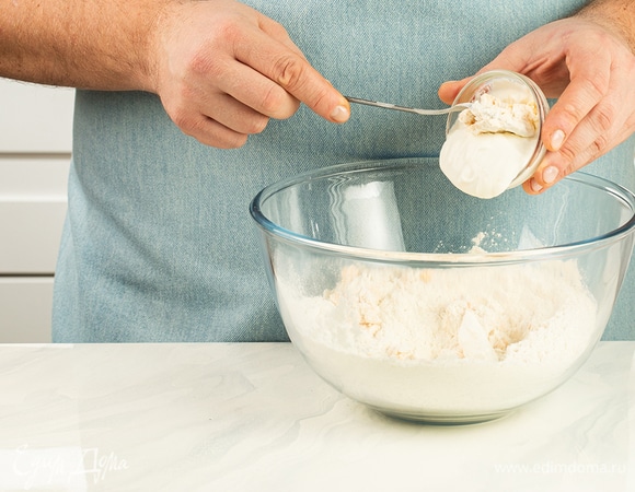 Замешивайте тесто, добавляя порциями сметану. Тесто должно получиться мягким. Накройте миску с тестом пищевой пленкой и поставьте в теплое место.