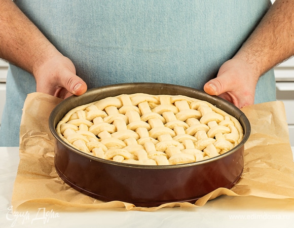 Из второй части теста вырежьте полоски. Накройте ими пирог, слегка прижимая к основе.