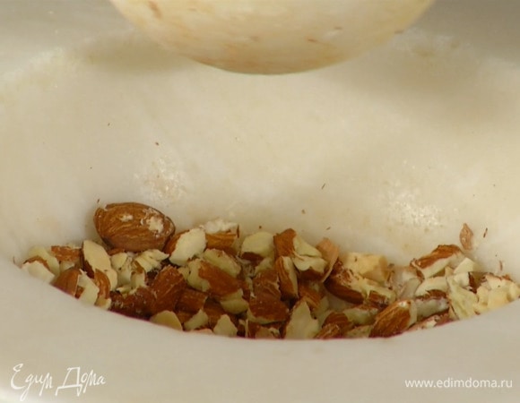 Миндаль измельчить в ступке в маленькие кусочки.