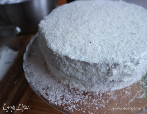 Верхний бисквит и бока смазать взбитыми сливками, обсыпать кокосовой стружкой через дуршлаг.
