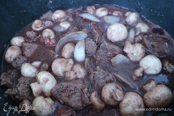 Поместить мясо с грибами в разогретую жаровню, добавить вино, мясо должно быть почти прикрыто вином. Подержать минут 10 жаровню на среднем огне с открытой крышкой. Крышку закрыть, огонь уменьшить до минимального, оставить на 30–40 минут. Открыть крышку, проверить соус на соль, сахар, сбалансировать вкус, если это будет необходимо. Закрыть неплотно крышку. Периодически проверять мясо, несколько раз надо перемешать, у меня на весь процесс тушения мяса в жаровне ушло 2 часа.