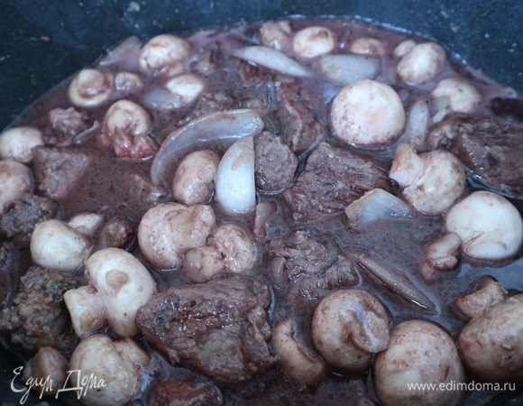 Поместить мясо с грибами в разогретую жаровню, добавить вино, мясо должно быть почти прикрыто вином. Подержать минут 10 жаровню на среднем огне с открытой крышкой. Крышку закрыть, огонь уменьшить до минимального, оставить на 30–40 минут. Открыть крышку, проверить соус на соль, сахар, сбалансировать вкус, если это будет необходимо. Закрыть неплотно крышку. Периодически проверять мясо, несколько раз надо перемешать, у меня на весь процесс тушения мяса в жаровне ушло 2 часа.