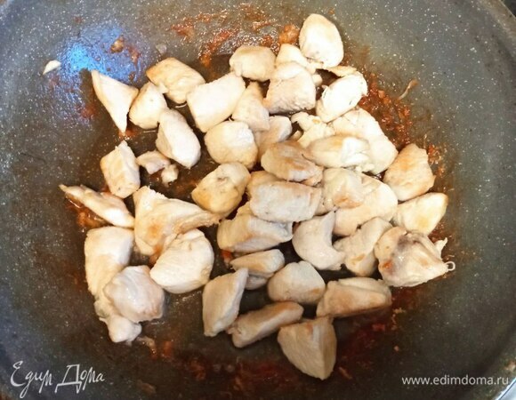 Куриную грудку промываем, обсушиваем бумажными полотенцами и режем некрупным кубиком. Острый перец мелко шинкуем. Можно нарезать кольцами. Я не вынимаю семечки и перегородки, но при желании можно это сделать, чтобы перец был не таким острым. В сковороде разогреваем растительное масло и кладем на полминуты перец, потом добавляем курицу. Обжариваем на сильном огне 2–3 минуты до образования корочки.