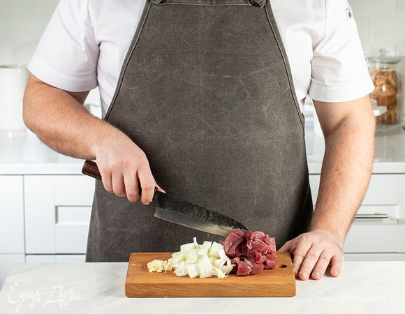 Говядину и лук нарежьте на кубики размером 1,5–2 см. Чеснок измельчите.