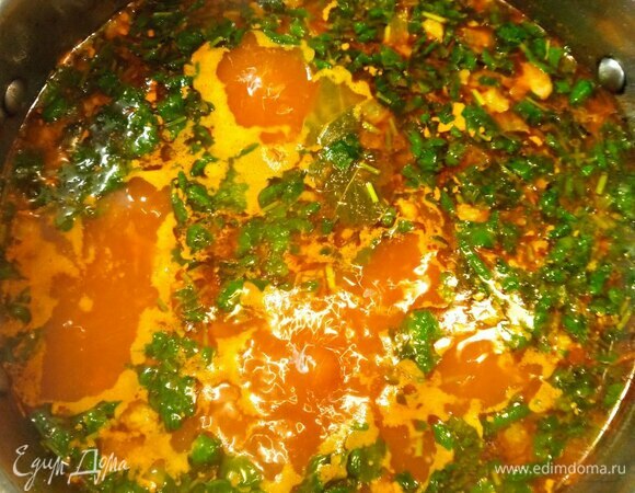 Из бульона вынимаем овощи и выбрасываем их. Достаем мясо и нарезаем на кусочки. Отправляем мясо обратно в бульон. Кладем лавровый лист, мелко нашинкованную зелень и чеснок.