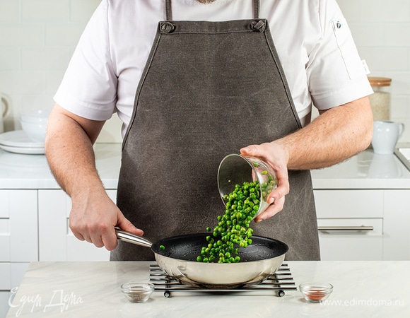 В эту же сковороду добавьте оставшееся оливковое масло и замороженный зеленый горошек. Посыпьте бобы молотой зирой и паприкой, жарьте в течение 5–7 минут.