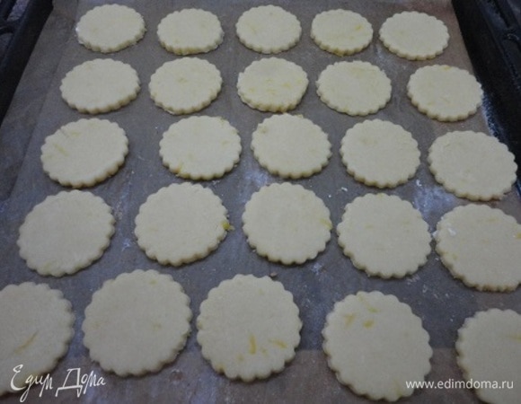 Включите духовку для разогрева на 180°C. Раскатайте тесто в пласт толщиной 5 мм и круглой формой с зубчиками вырежьте печенье. Выложите его на противень и выпекайте 15 минут. Ориентируйтесь на свою духовку. Не пересушите, иначе оно потеряет свою нежность. Печенье должно быть светлое, не загорелое.