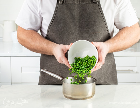 Зеленый горошек переложите в сотейник, залейте водой, доведите до кипения и варите в течение 2 минут.