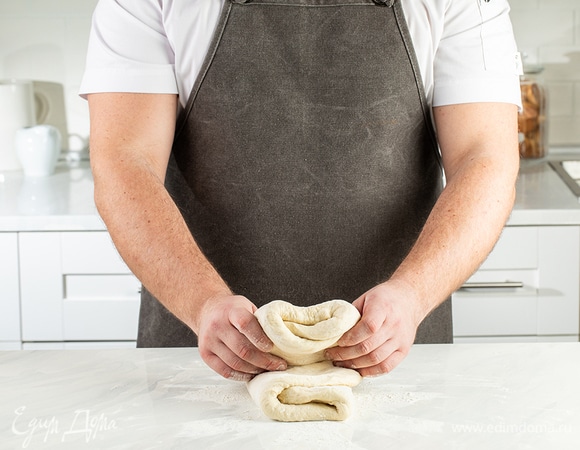 Сложите тесто в три слоя, затем еще раз пополам. Разрежьте на две равные части.