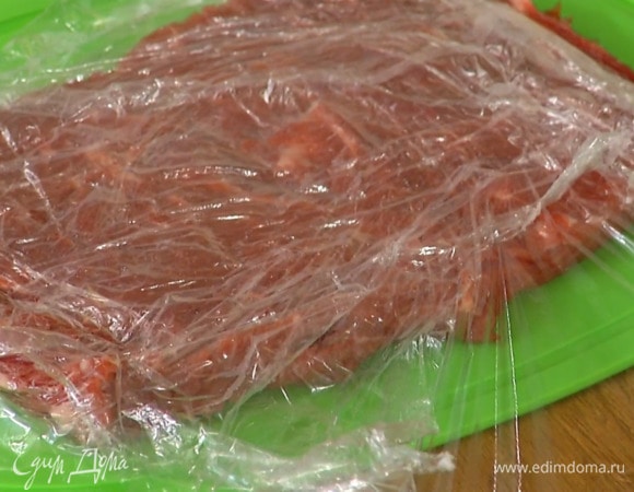 Вырезку разрезать вдоль пополам и разложить в длинный пласт, затем накрыть пищевой пленкой и отбить так, чтобы толщина мяса была 1–1 1/2 см.