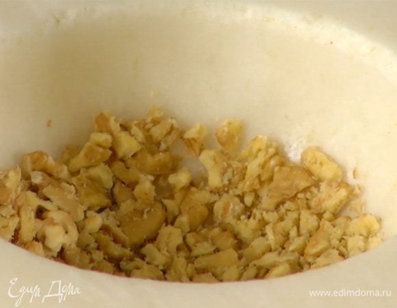 Грецкие орехи измельчить в ступке на кусочки.