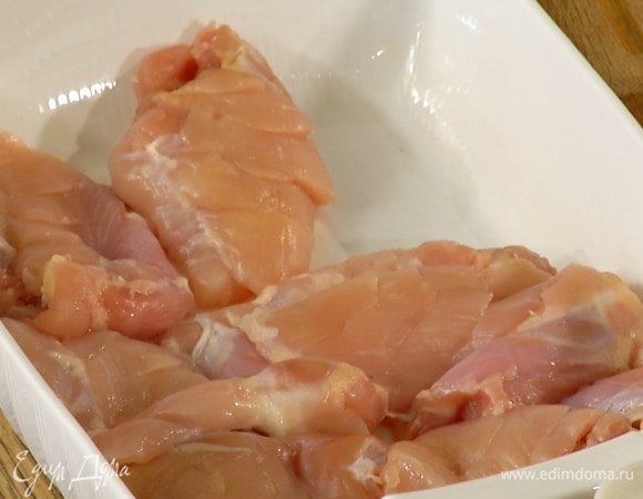 Куриное филе, сделав с внешней стороны неглубокие надрезы, выложить в жаропрочную керамическую форму.