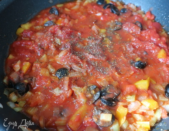 Добавить маслины, помидоры в собственном соку, посолить, поперчить, добавить итальянские травы.