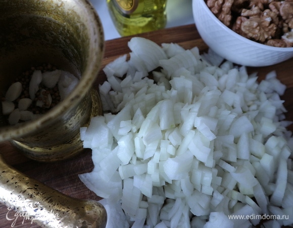 Чеснок нарезать, поместить в ступку вместе с кориандром, солью, растолочь. Мелко нарезать лук. На сковороду с оливковым маслом поместить лук, обжарить на медленном огне до прозрачности.