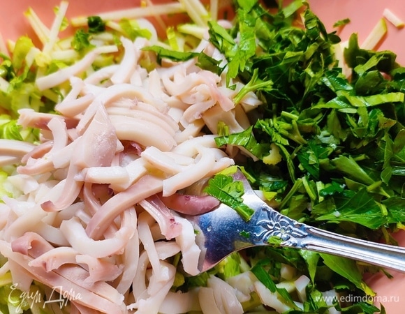 Тушки кальмаров очистить и опустить в кипящую воду. Варить 3 минуты. Остудить и нарезать тонкой соломкой. Петрушку мелко нарезать.