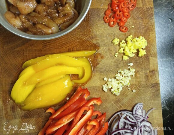 Куриную грудку промываем, обсушиваем бумажными полотенцами и нарезаем тонкими полосками. Маринуем в соевом соусе с добавлением молотого имбиря минут 30. Тем временем нарезаем овощи: лук — полукольцами, болгарский перец и манго — полосками, перец чили — кружочками, чеснок и корень имбиря мелко шинкуем. Крахмал разводим в половине стакана воды.