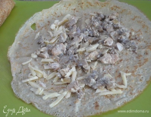 Круглое жароупорное блюдо или сковороду 26 см диаметром смазать растительным маслом. На каждый блин выложить небольшое количество сыра и начинки. И свернуть трубочкой.