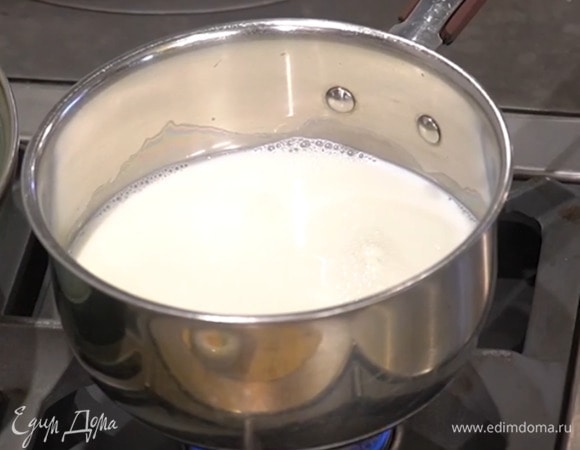 Молоко влить в кастрюлю, добавить 200 мл горячей кипяченой воды и прогреть на маленьком огне так, чтобы молоко стало горячим, но не кипело.