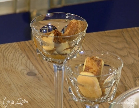 Печенье савоярди разломить на 2–3 части, разложить в бокалы и полить половиной горячего кофе, затем выложить сливочную массу, посыпать сверху раскрошенным амаретти и полить оставшимся кофе.